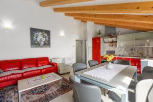 a living room with a table and a red couch at Apartment Seafront Mia in Umag