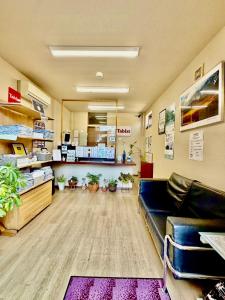 a waiting room with a leather couch in a pharmacy at Tabist International Hotel Kaike in Yonago