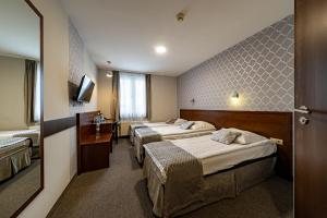 a hotel room with three beds and a television at Hotel Fero Express POKOJE KLIMATYZOWANE AC in Krakow +42 photos