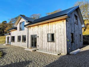 a large wooden house with a lot of windows at Faodail House in Portree