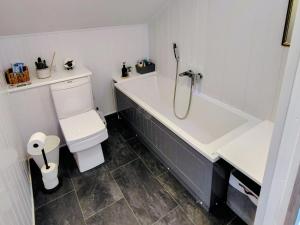 a white bathroom with a tub and a toilet at Faodail House in Portree +21 photos