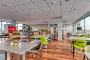 a restaurant with tables and chairs and a cafeteria at ibis Berlin Messe in Berlin