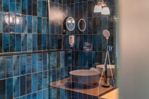 a bathroom with a blue tiled wall with a shower at Le B. Suites, Chambres & Restaurant in Riquewihr +43 photos