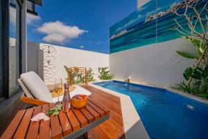a room with a swimming pool and a table with a drink at 2BR villa w - pool & beach access in Mengwi