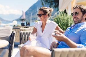 a man and a woman sitting on a chair at Seehotel Einwaller - adults only in Pertisau