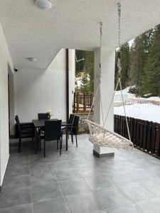 a patio with a table and chairs and a swing at Четири сезона 12 in Stoykite