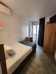 a hotel room with a bed and a window at Hôtel Alizé in Cannes