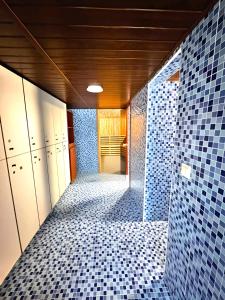 a room with a hallway with blue tiles on the wall at Zajazd Rest in Przemyśl