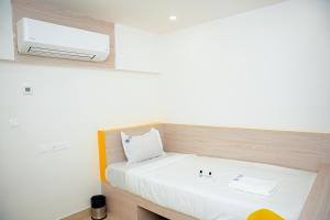 a small room with a bed and a tv at Global Inn & Suites in Mangalore