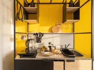 a kitchen with yellow walls and a sink at Dimora dei Colori - Yellow Light in Bari