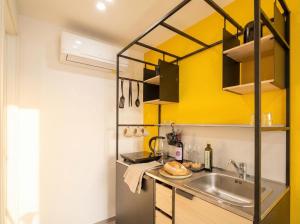 a kitchen with a sink and a yellow wall at Dimora dei Colori - Yellow Light in Bari