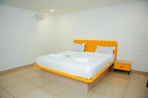 a bedroom with a large bed with a wooden headboard at Global Inn & Suites in Mangalore