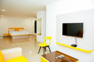 a living room with a tv on a wall at Global Inn & Suites in Mangalore