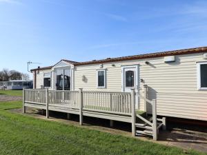 a white mobile home with a porch and a deck at Towervans Z11 in Mablethorpe
