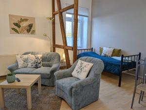 a living room with two chairs and a bed at Ferienwohnung Barbarossa - Benno in Rottleben