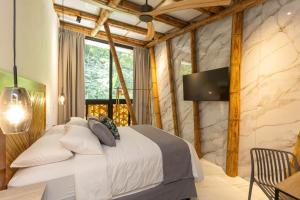a bedroom with a large bed and a window at Dos Olas Ocean-Inspired Luxury Villa in Quepos