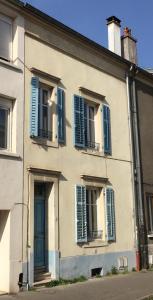 a building with blue shuttered windows and a blue door at Maison Nancy Thermal in Nancy