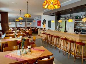 a restaurant with wooden tables and chairs and a bar at Gasthaus Bidinger in Schoden