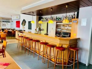 a bar with red stools in a restaurant at Gasthaus Bidinger in Schoden +10 photos