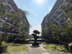 a courtyard of an apartment building with a tree at New Jimbaran Hotel in Ungasan