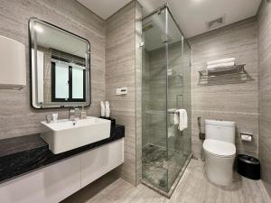 a bathroom with a sink and a toilet and a mirror at GEM Hotel And Residence in Hanoi +51 photos
