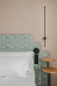 a bedroom with a white bed with a patterned headboard at Vincci Soma in Madrid