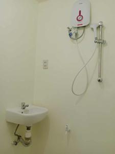 a white bathroom with a sink and a shower at The Soul Center in Batuan