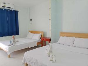 a room with two beds and a blue curtain at The Soul Center in Batuan