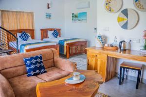 a living room with a couch and a bed at Sea Eagle Oceanfront in Buyuni