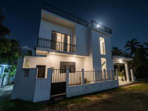 a white house with a balcony at night at Sea Line Villa in Galle +6 photos