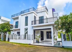 a white house with balconies and trees at Sea Line Villa in Galle