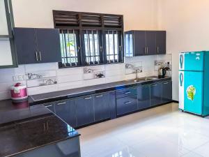 a kitchen with blue cabinets and a blue refrigerator at Sea Line Villa in Galle
