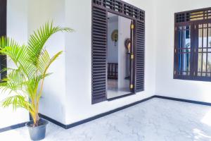 a house with a door and a plant in a courtyard at Sea Line Villa in Galle
