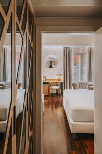 a bedroom with two beds and a table at Vincci Soma in Madrid