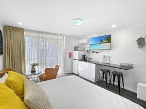 a room with a bed and a kitchen with a counter at Charming Studio Apartment in Mandurah in Mandurah