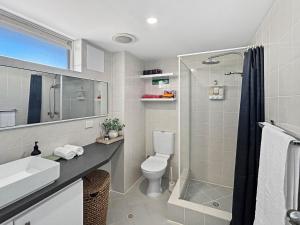 a bathroom with a toilet and a sink and a shower at Charming Studio Apartment in Mandurah in Mandurah