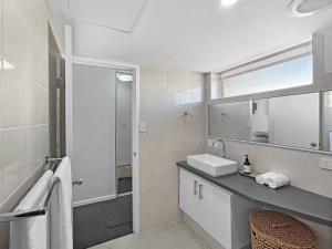 a bathroom with a sink and a mirror at Charming Studio Apartment in Mandurah in Mandurah +2 photos