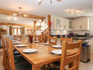 a dining room and kitchen with a wooden table and chairs at Swallows Reach in Totnes