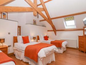 two beds in a room with wooden ceilings at Swallows Reach in Totnes +54 photos
