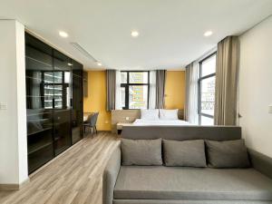 a bedroom with a bed and a couch in a room at GEM Hotel And Residence in Hanoi