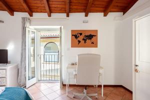 a white room with a desk and a table and a window at Like Home XX Settembre in Sesto Calende