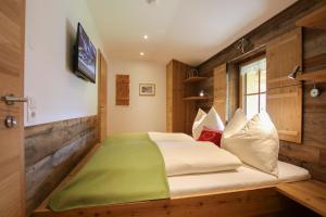 a bedroom with a bed with a green blanket on it at Obersinnlehenhof in Maishofen