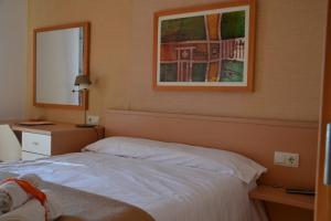 サンティアゴ・デ・コンポステーラにあるペンシオン ダ エストレラのベッドルーム1室(ベッド1台付)が備わります。壁に絵が飾られています。