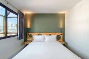 a bedroom with a large white bed with a window at Mybed Sathorn Hotel in Bangkok