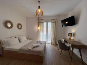 a bedroom with a bed and a desk and a television at Calm Joy & J - New Bird in Ermoupoli