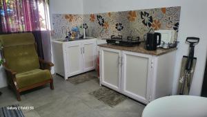 a small kitchen with white cabinets and a chair at Chambre Studio Bas Prix in Port Louis +9 photos