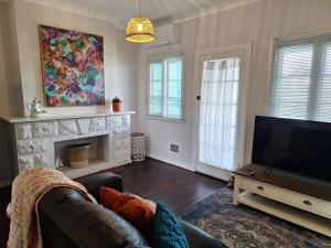 a living room with a couch and a flat screen tv at South Bunbury Beach Shack in Bunbury +9 photos