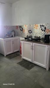 a kitchen with white cabinets and a sink at Chambre Studio Bas Prix in Port Louis