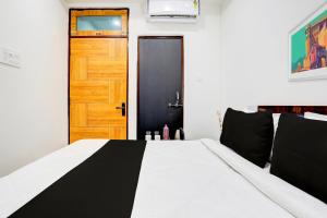 a bedroom with a black and white bed and a door at Hotel O BGPG House in Varanasi