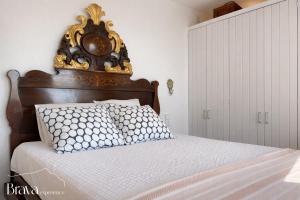 a bed with an ornate headboard in a bedroom at Es Forn - Vistas panorámicas a la bahía I terraza privada I 5 dormitorios I chimenea I centro histórico I Brava Experience in Cadaqués +51 photos